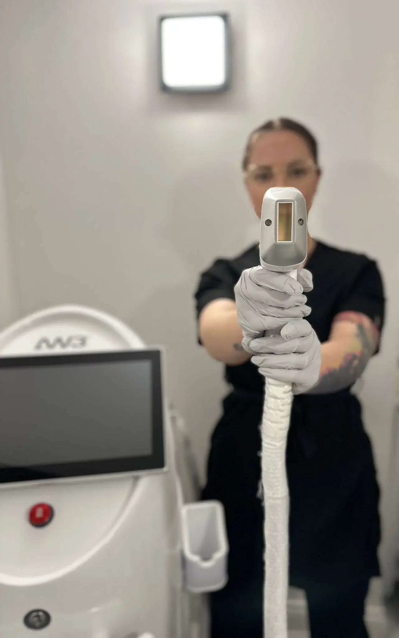 Expert showing machine that is used in beauty salon getBeauty in Cambridge for laser hair removal treatments