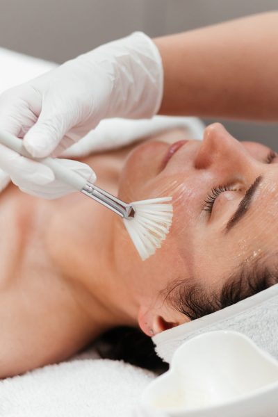 Cosmetology beauty procedures. Lady receiving rejuvenation anti aging treatment, facial chemical peel therapy in beauty salon or medical center. Wellness.